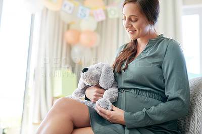 Buy stock photo Shot of a young mother to be holding a soft toy meant for her child