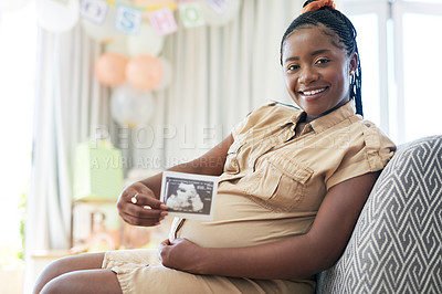Buy stock photo Shot of a young mother to be holding an ultrasound of her unborn child