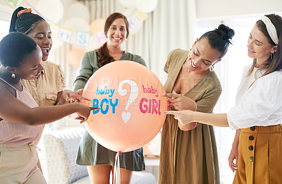 Buy stock photo Shot of a group of women about to pop a balloon for a gender reveal during a baby shower