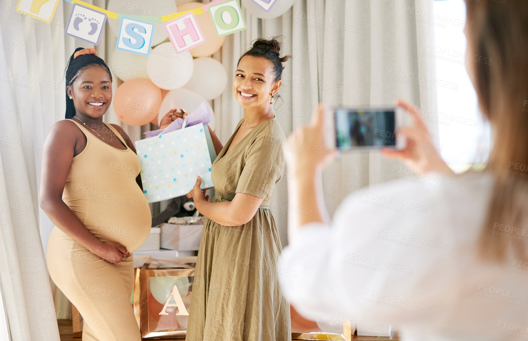 Buy stock photo Baby shower, photograph or friends in home with smile, phone or social media post at celebration. Happy, mom or women with gift, motherhood connection or memory capture at gender reveal party
