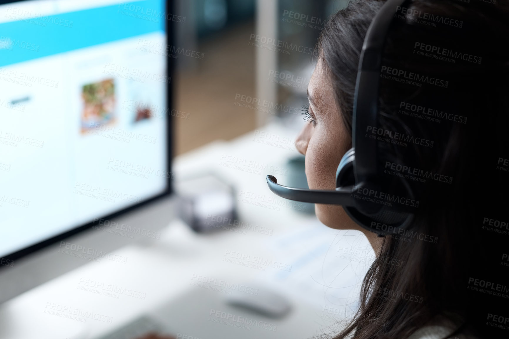 Buy stock photo Shot of a young woman using a headset and computer in a modern office