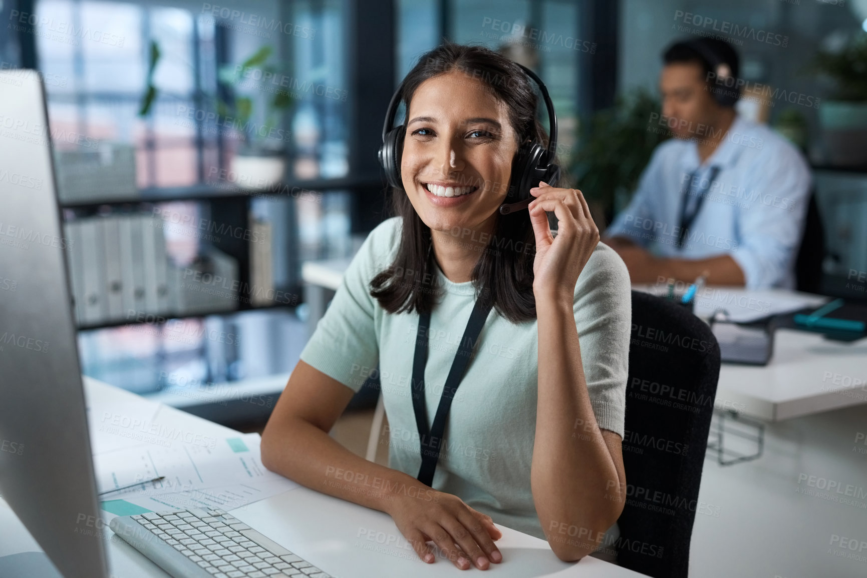 Buy stock photo Portrait of a young woman using a headset and computer in a modern office