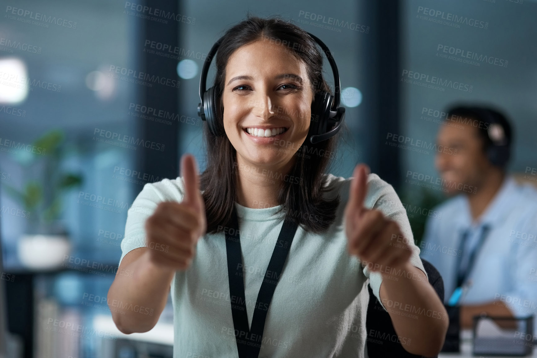 Buy stock photo Portrait of a young woman using a headset and showing thumbs up in a modern office