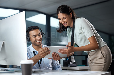 Buy stock photo Shot of a young man and woman using a digital tablet while working in a call centre