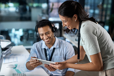 Buy stock photo Shot of a young man and woman using a digital tablet while working in a call centre