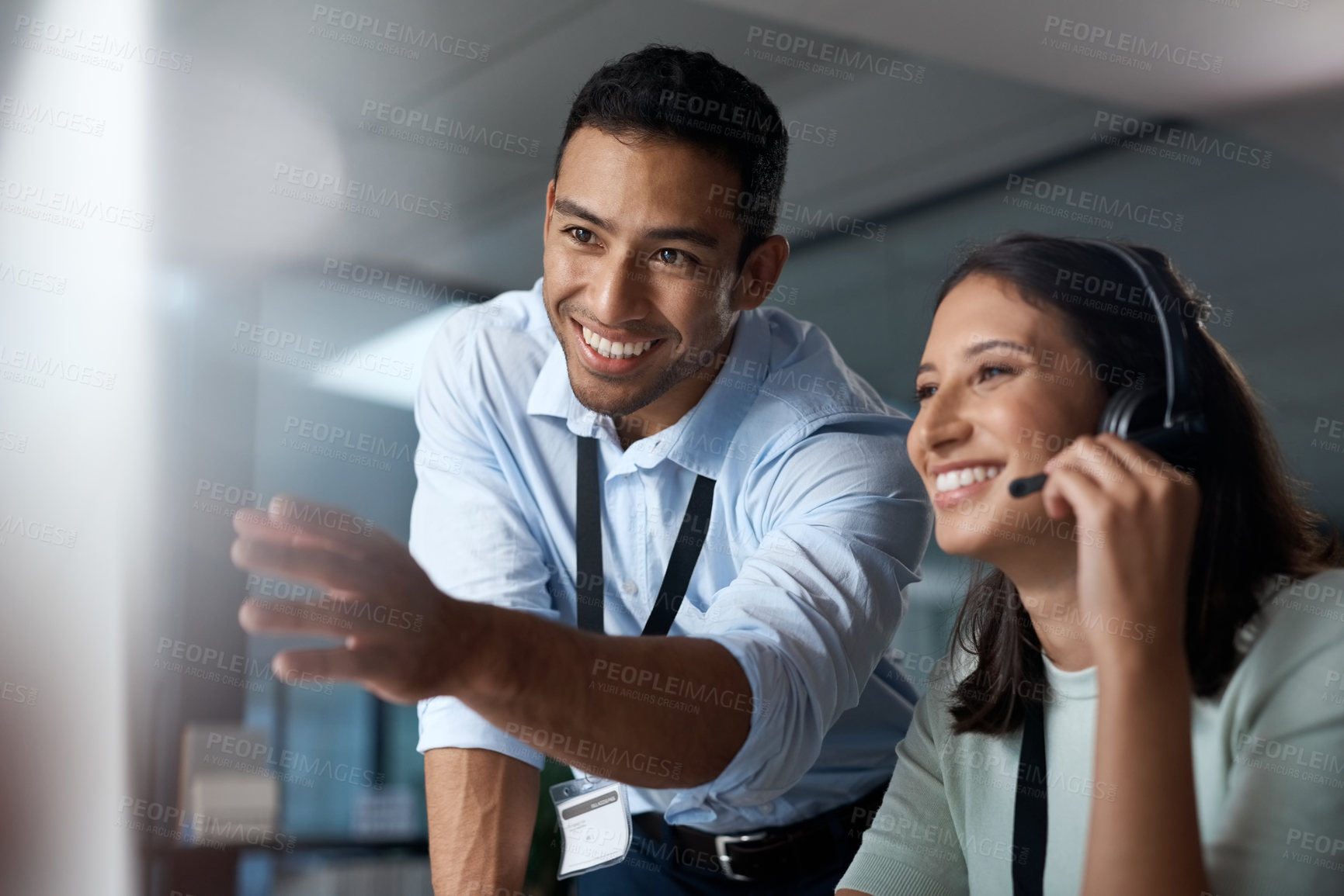 Buy stock photo Shot of a young man and woman using a computer while working in a call centre