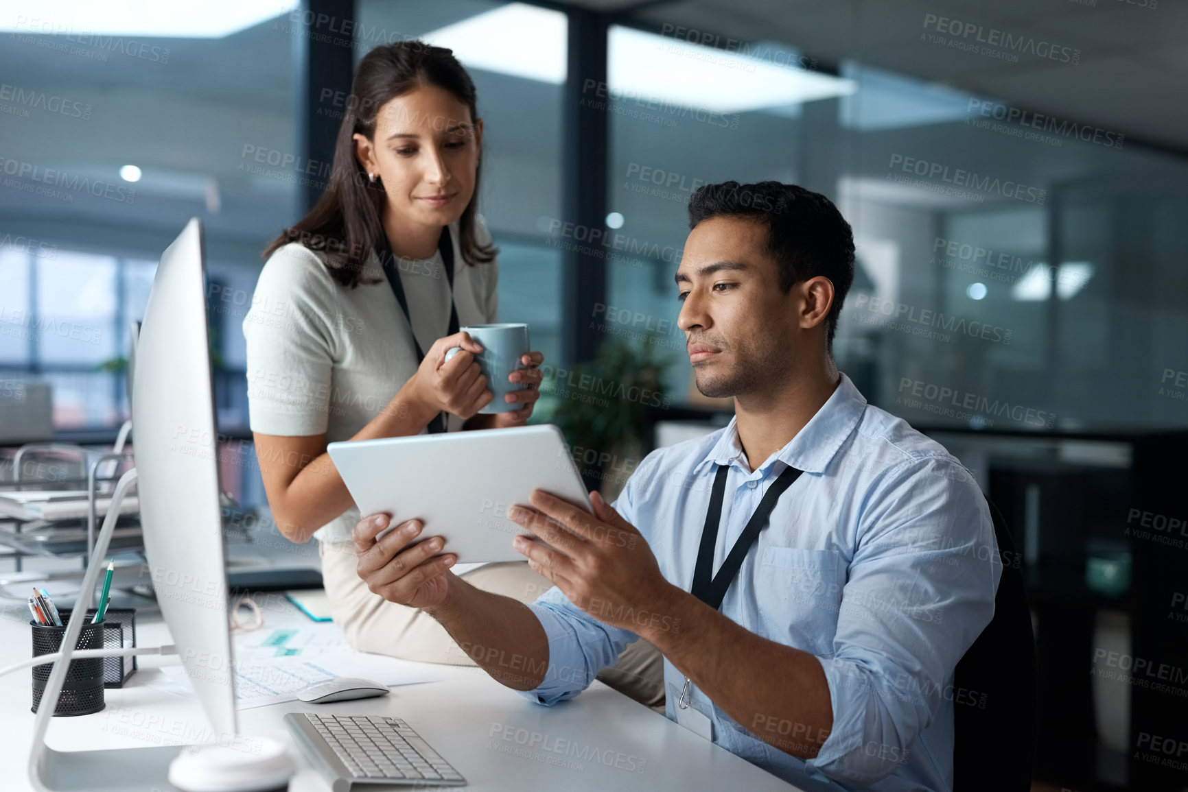 Buy stock photo Shot of a young businessman and businesswoman using a digital tablet in a modern office