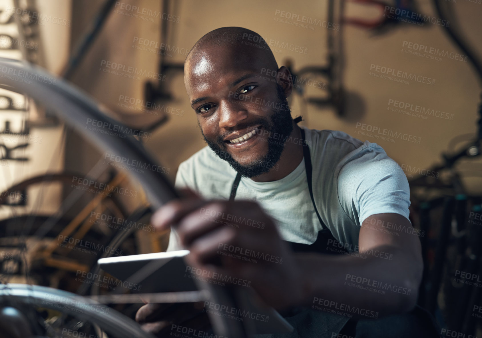 Buy stock photo Portrait of a young man holding a digital tablet working at a bicycle repair shop