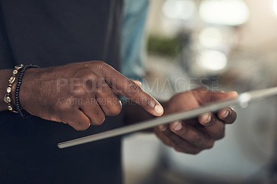 Buy stock photo Cropped shot of an unrecognizable man standing alone in his bicycle shop and using a digital tablet