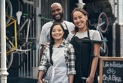 Buy stock photo Portrait of three young colleagues standing outside their bicycle repair shop