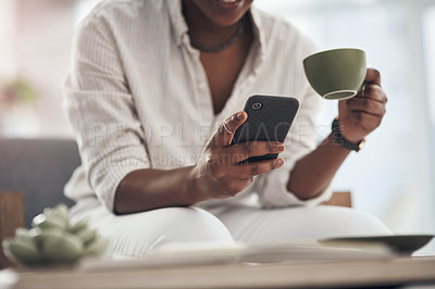 Buy stock photo Shot of a businesswoman using her smartphone to send text messages while drinking coffee