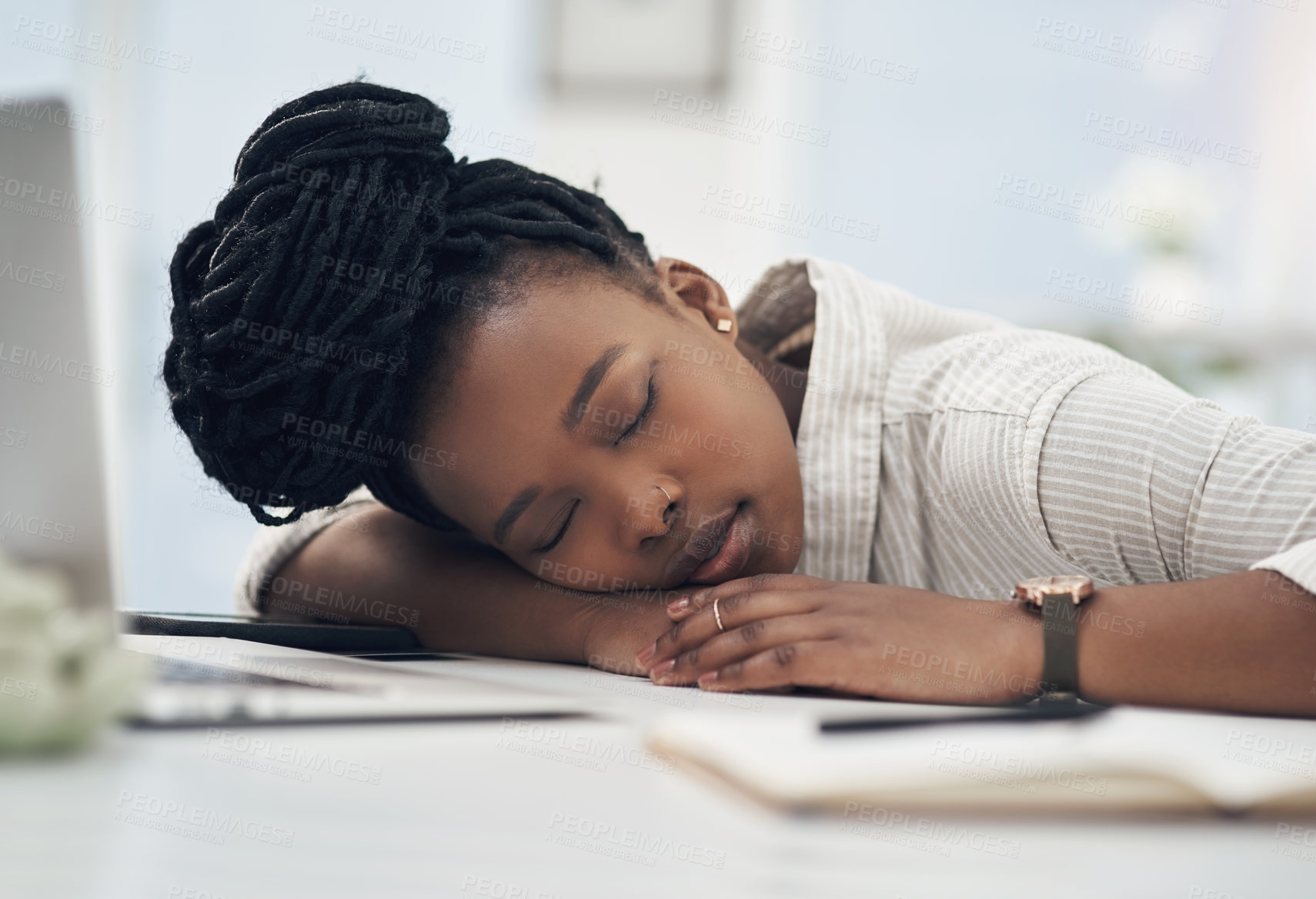 Buy stock photo Shot of a young businesswoman taking a nap on her desk at work