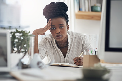 Buy stock photo Shot of a young businesswoman looking stressed at her office desk