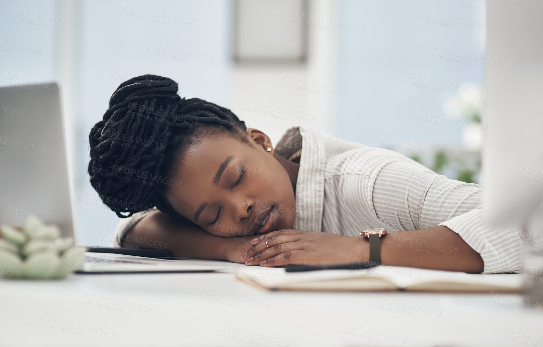 Buy stock photo Shot of a young businesswoman taking a nap on her desk at work