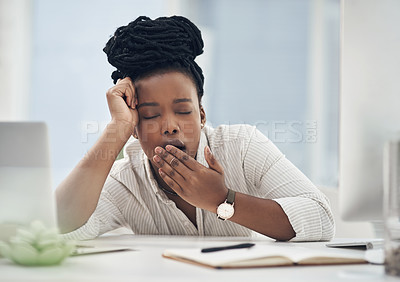 Buy stock photo Shot of a young businesswoman yawning at her desk