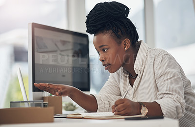 Buy stock photo Shot of a young businesswoman using her laptop at work