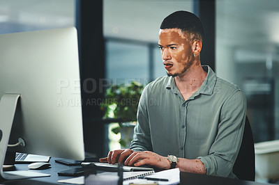 Buy stock photo Shot of a young businessman using a computer in an office at work