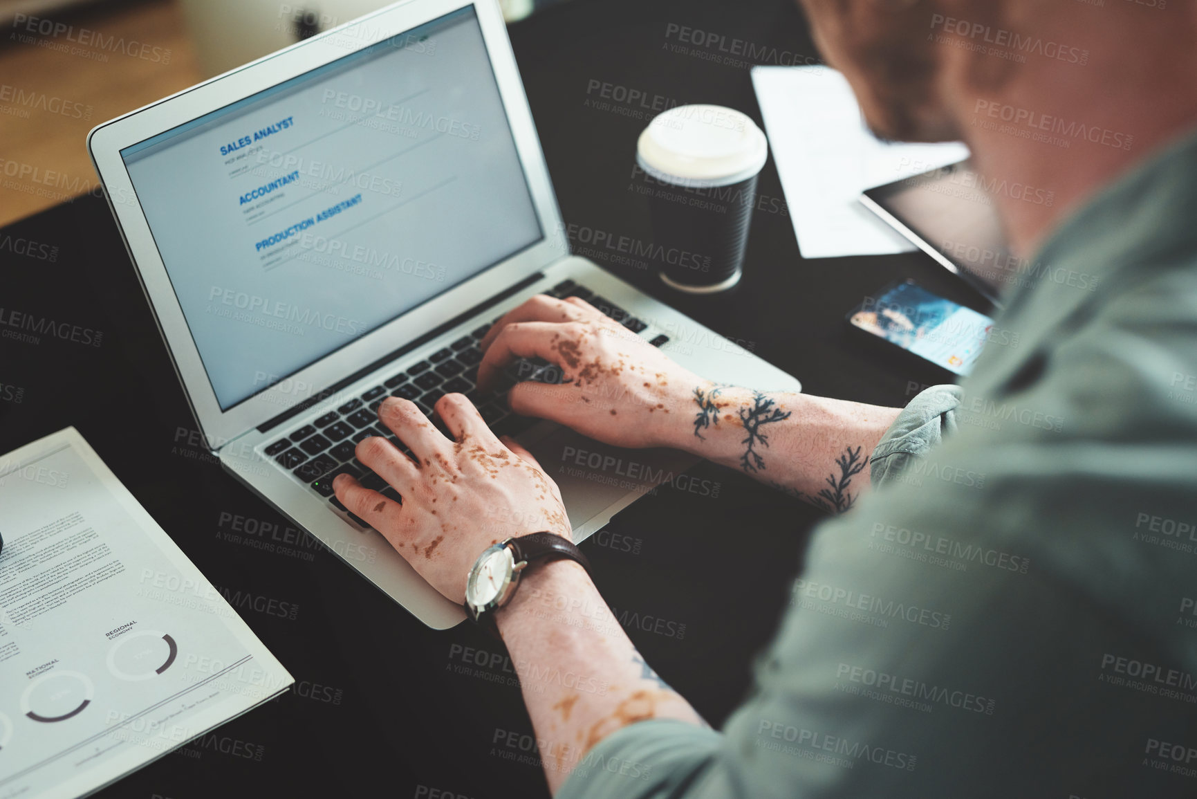 Buy stock photo Shot of a young businessman using a laptop in an office at work