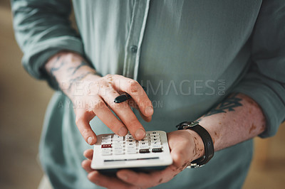 Buy stock photo Shot of an unrecognizable businessman using a calculator in an office at work