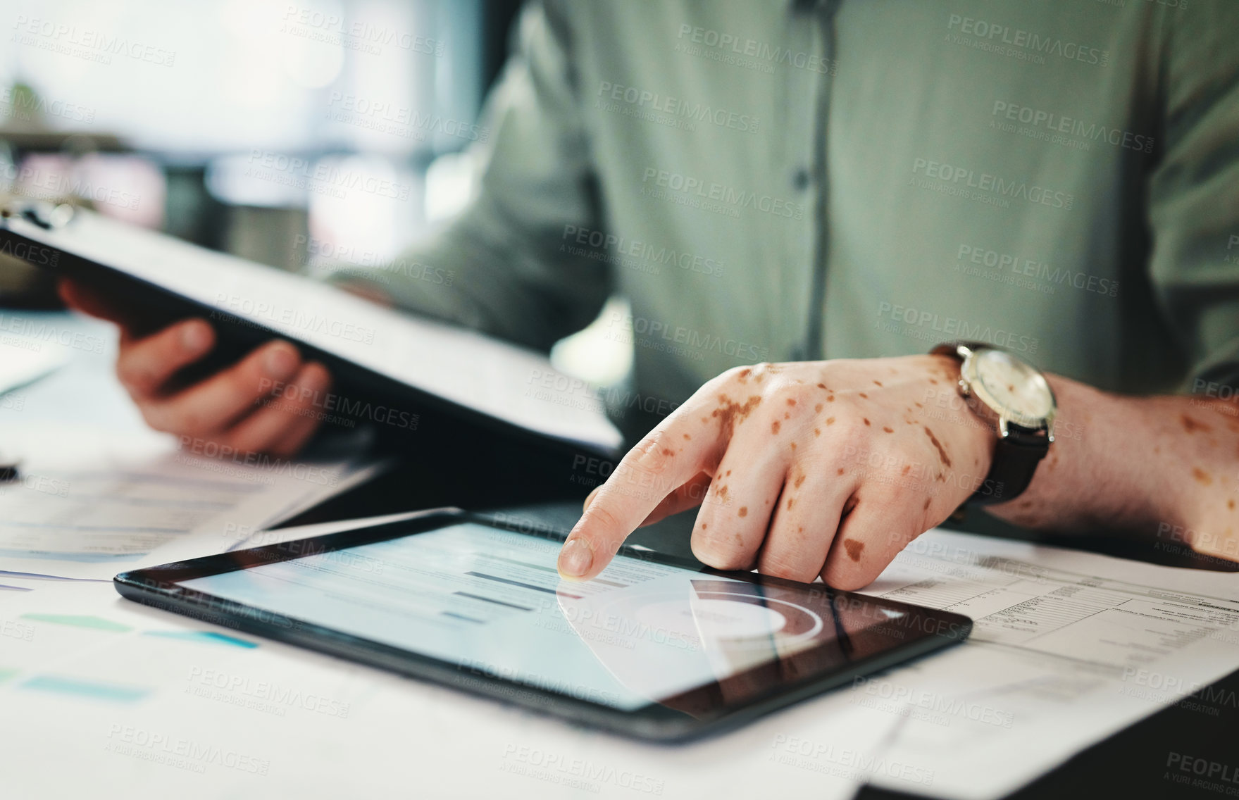 Buy stock photo Shot of an unrecognizable businessman using a digital tablet in an office at work