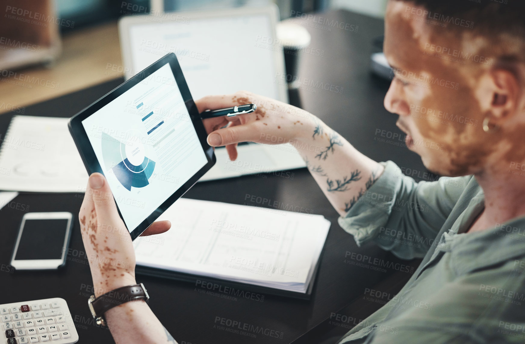 Buy stock photo Shot of an young businessman using a digital tablet in an office at work