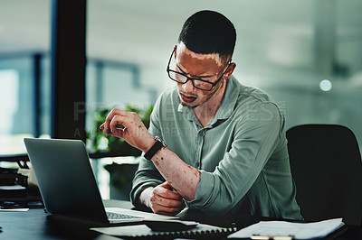 Buy stock photo Shot of a young businessman checking the time in an office at work