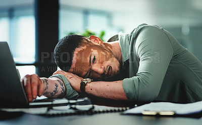 Buy stock photo Shot of a young businessman sleeping in an office at work