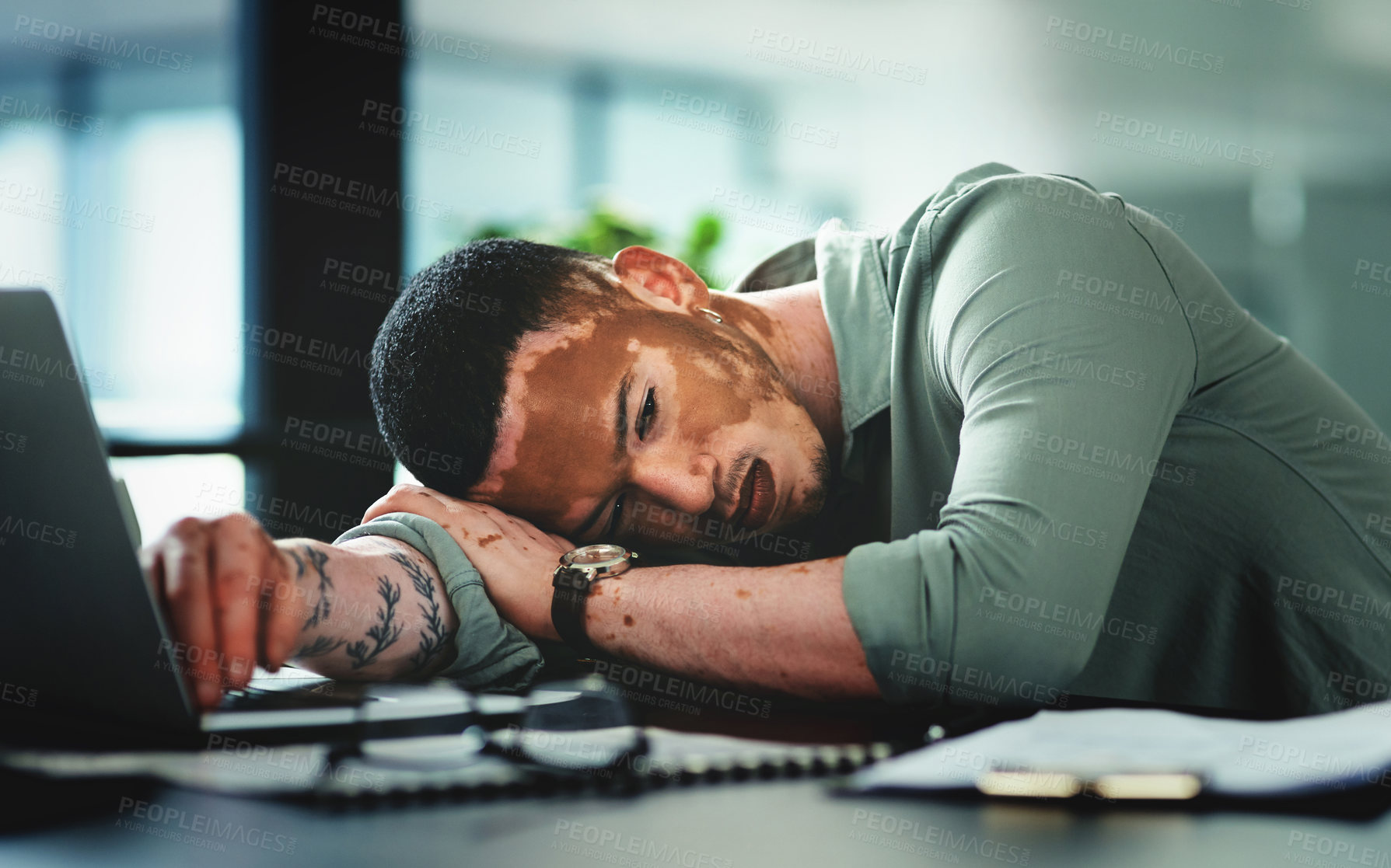 Buy stock photo Shot of a young businessman sleeping in an office at work