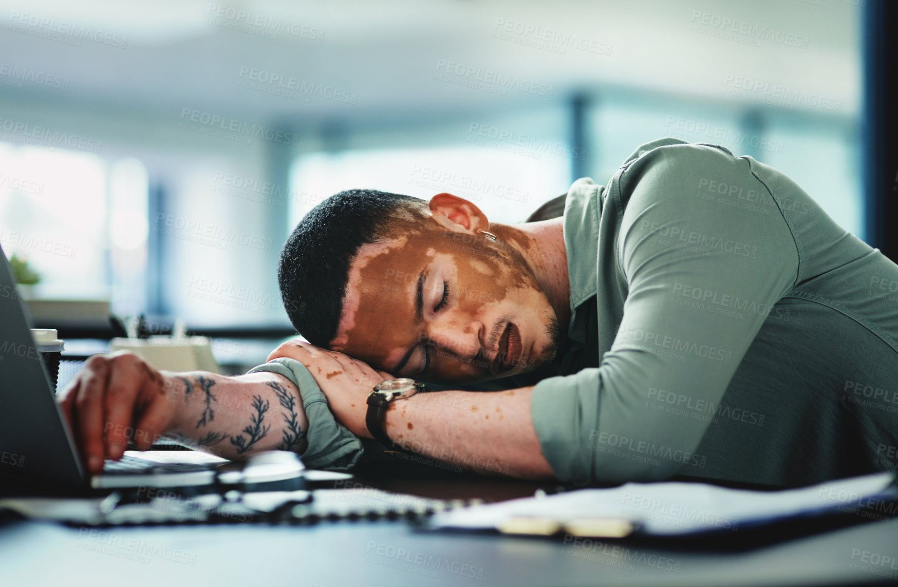 Buy stock photo Shot of a young businessman sleeping in an office at work