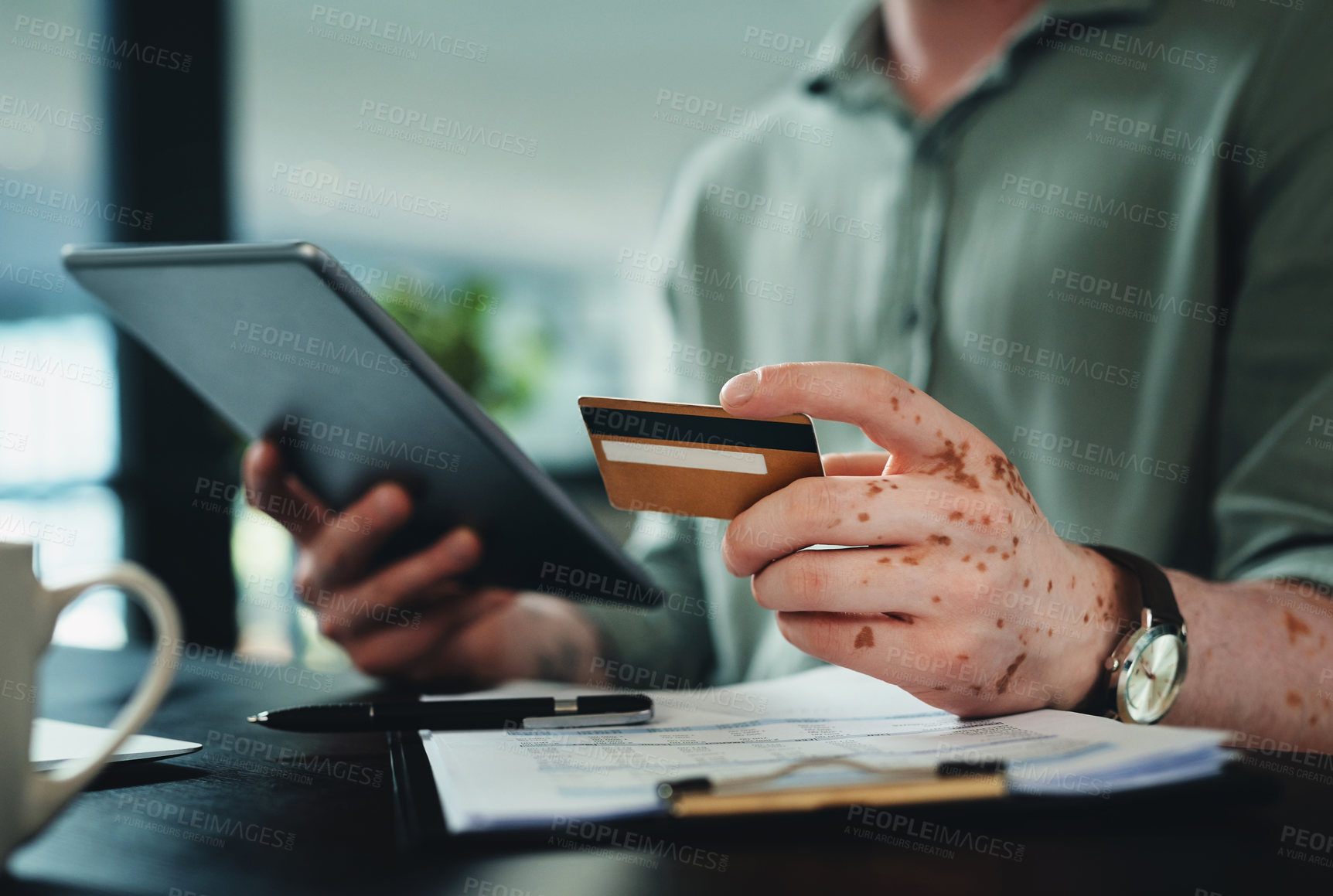 Buy stock photo Shot of n unrecognizable businessman holding a credit card while using a digital tablet in an office