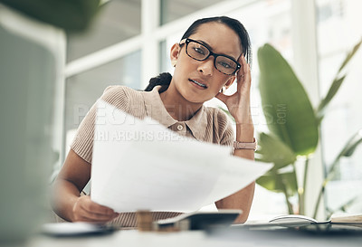 Buy stock photo Portrait of a young businesswoman looking stressed out while calculating finances in an office