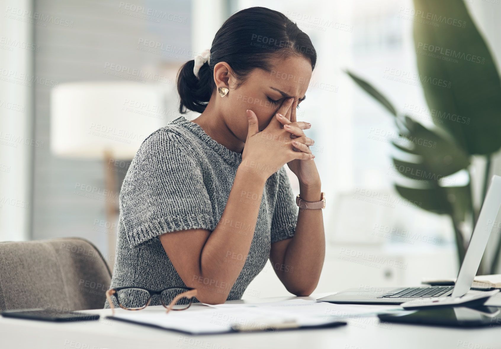 Buy stock photo Shot of a young businesswoman looking stressed out while working in an office