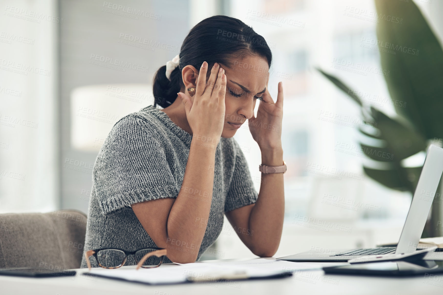 Buy stock photo Shot of a young businesswoman looking stressed out while working in an office