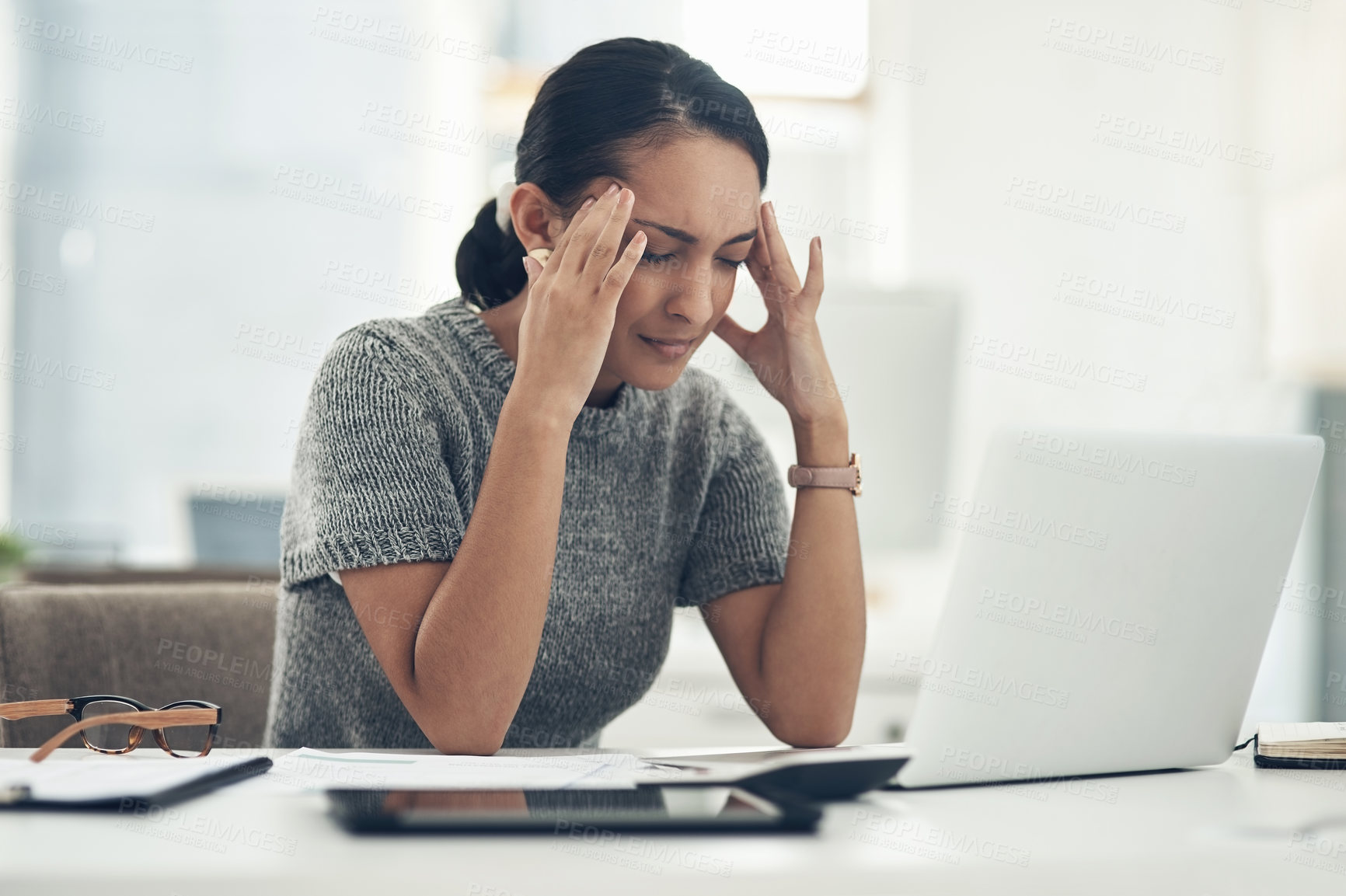 Buy stock photo Shot of a young businesswoman looking stressed out while working in an office