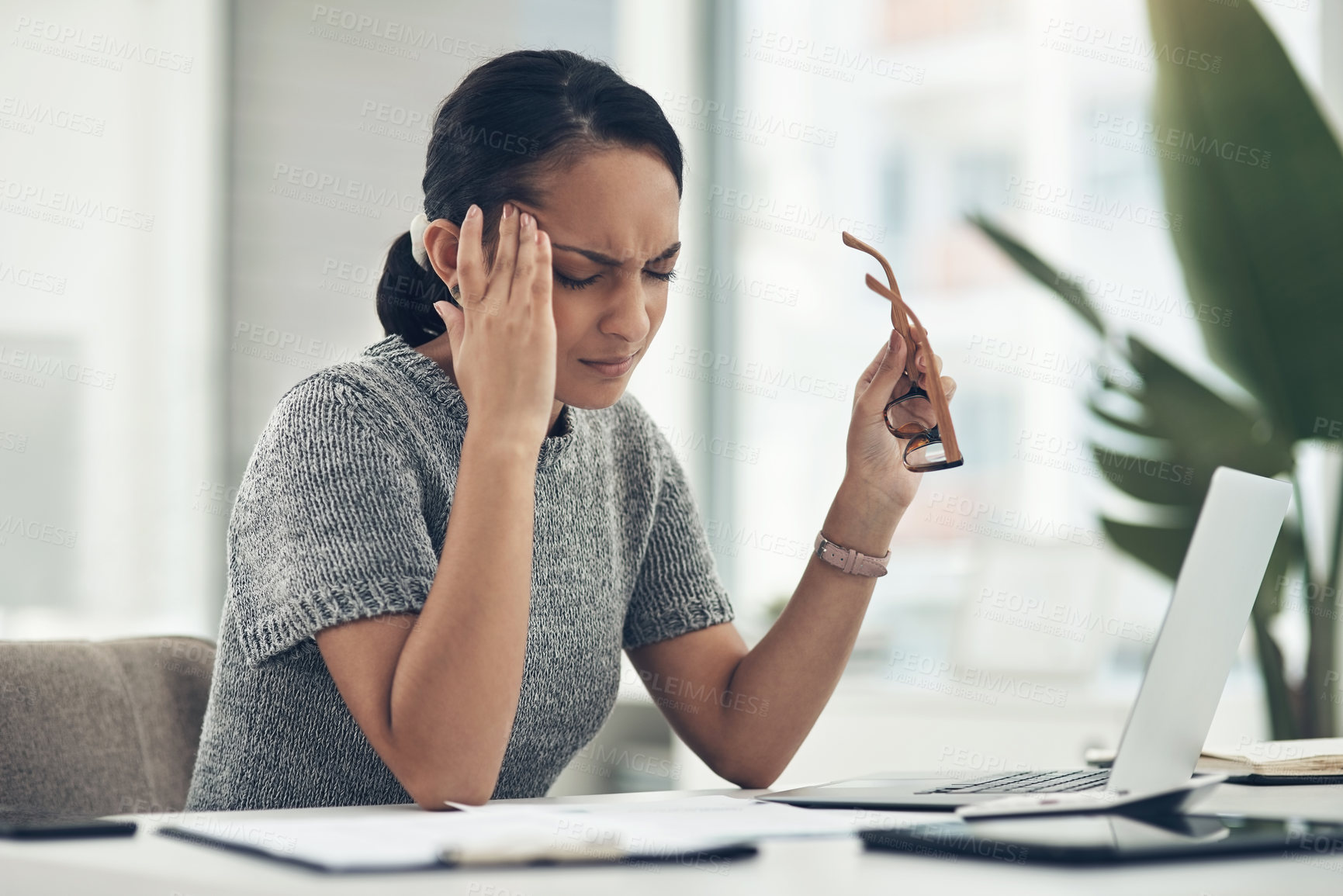 Buy stock photo Shot of a young businesswoman looking stressed out while working in an office