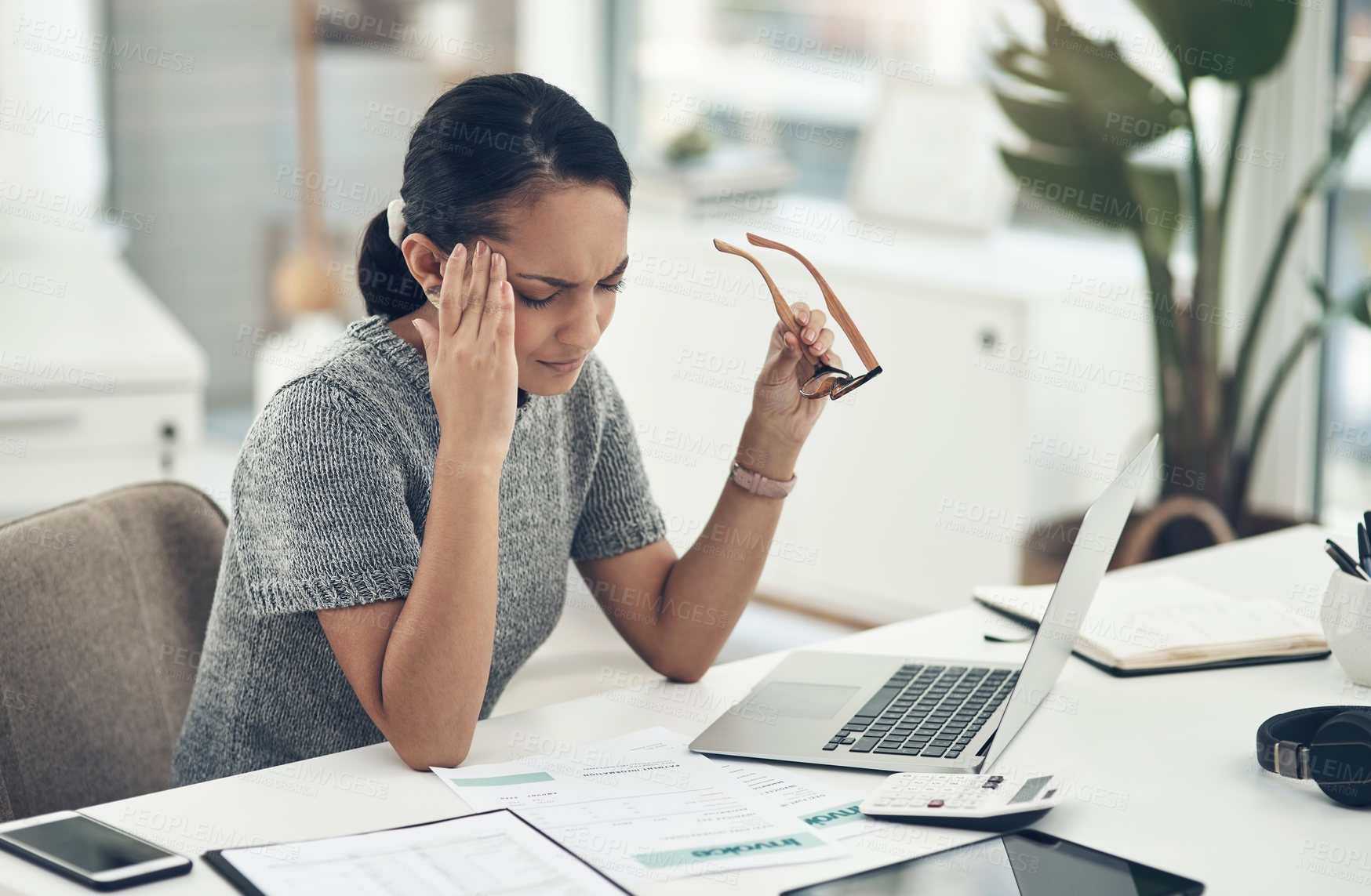 Buy stock photo Shot of a young businesswoman looking stressed out while working in an office