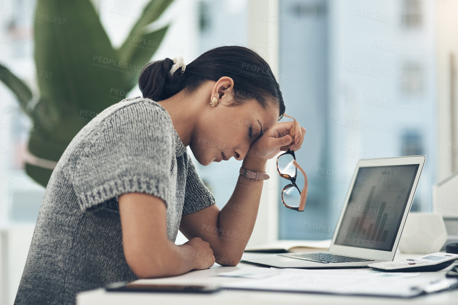 Buy stock photo Shot of a young businesswoman looking stressed out while working in an office