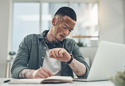 Buy stock photo Shot of a young business man checking his watch in a modern office