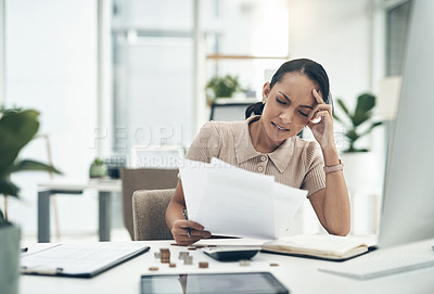 Buy stock photo Shot of a young businesswoman looking stressed out while calculating finances in an office