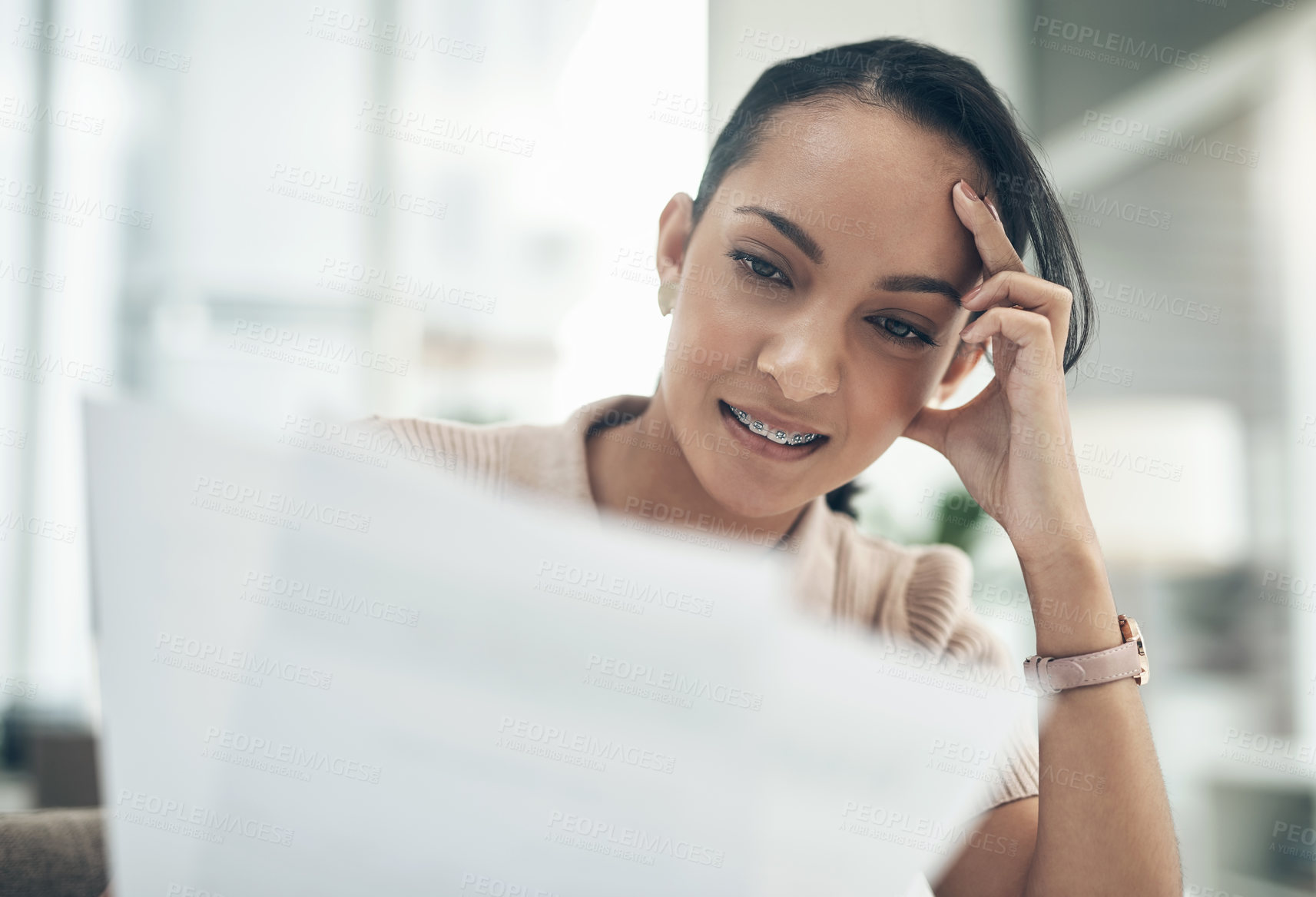 Buy stock photo Shot of a young businesswoman going through paperwork in an office