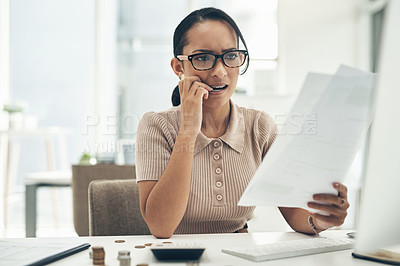 Buy stock photo Shot of a young businesswoman looking stressed out while calculating finances in an office