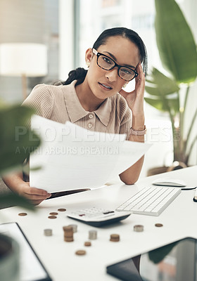 Buy stock photo Portrait of a young businesswoman looking stressed out while calculating finances in an office