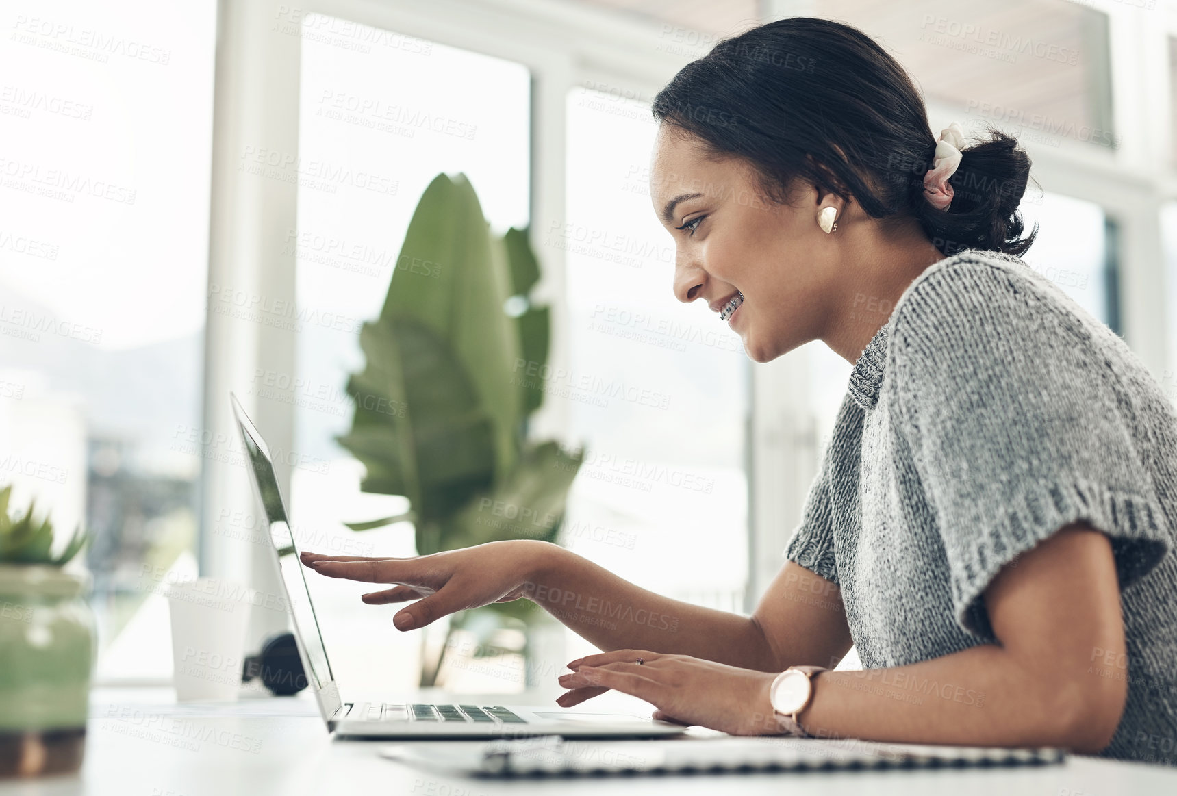 Buy stock photo Shot of a young businesswoman working on a laptop in an office