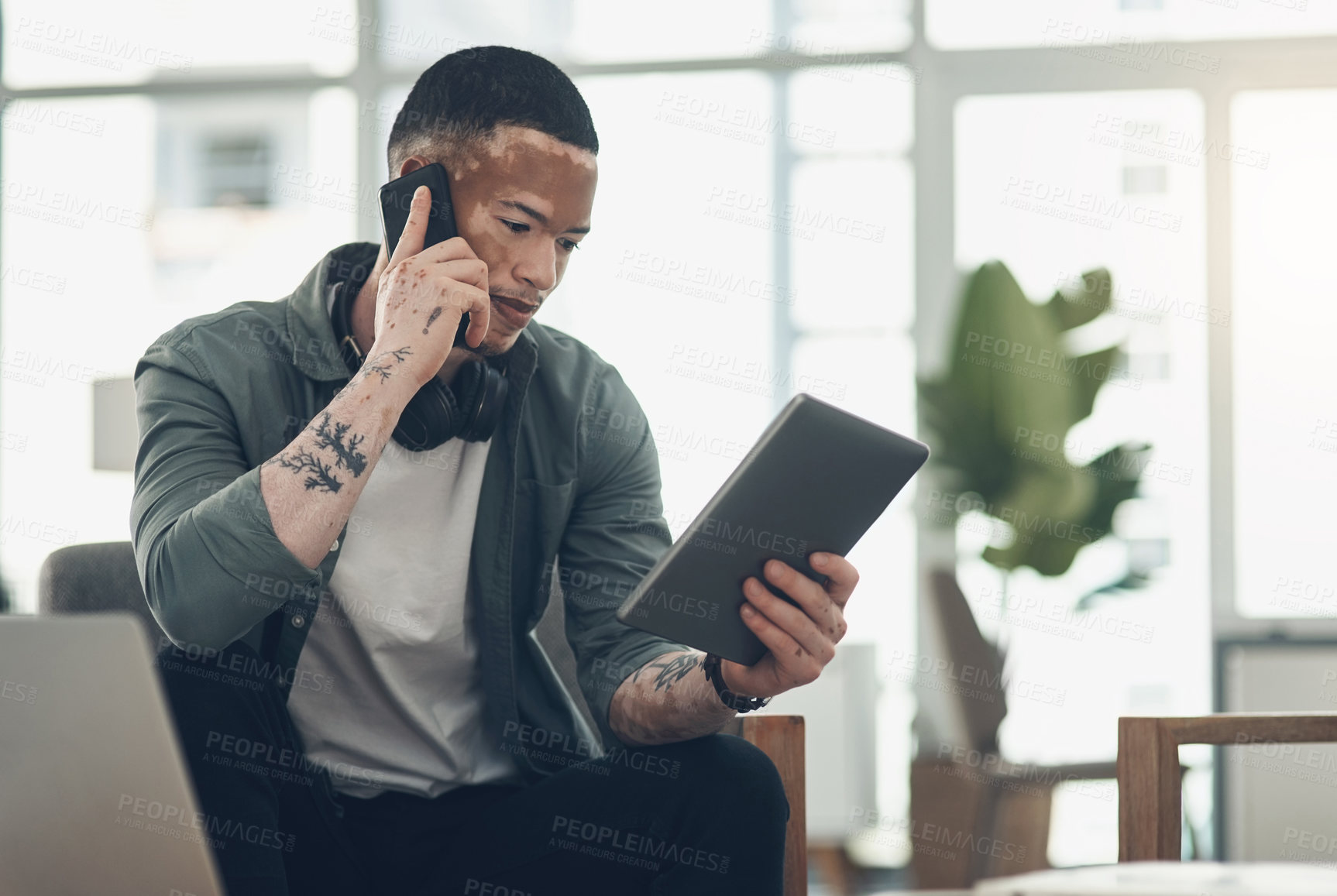 Buy stock photo Shot of a young business man on a phone call in a modern office