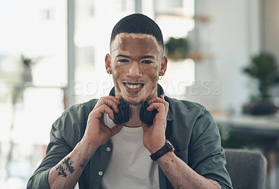 Buy stock photo Shot of a young business man using headphones at work