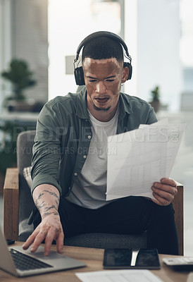 Buy stock photo Shot of a young business man using headphones at work
