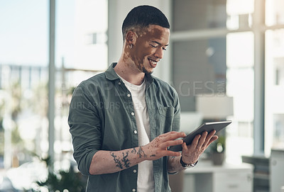 Buy stock photo Shot of a young business man using a tablet at work