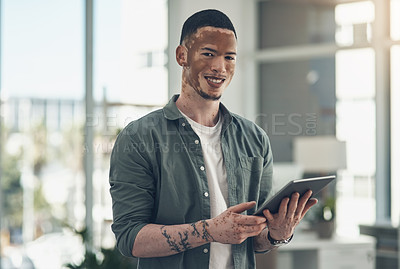Buy stock photo Shot of a young business man using a tablet at work