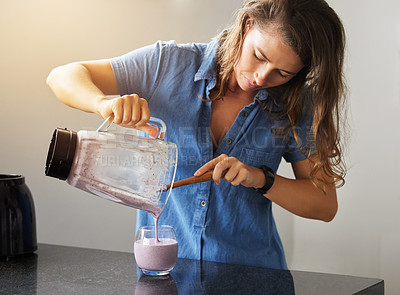 Buy stock photo Shot of a young female preparing a smoothy at home