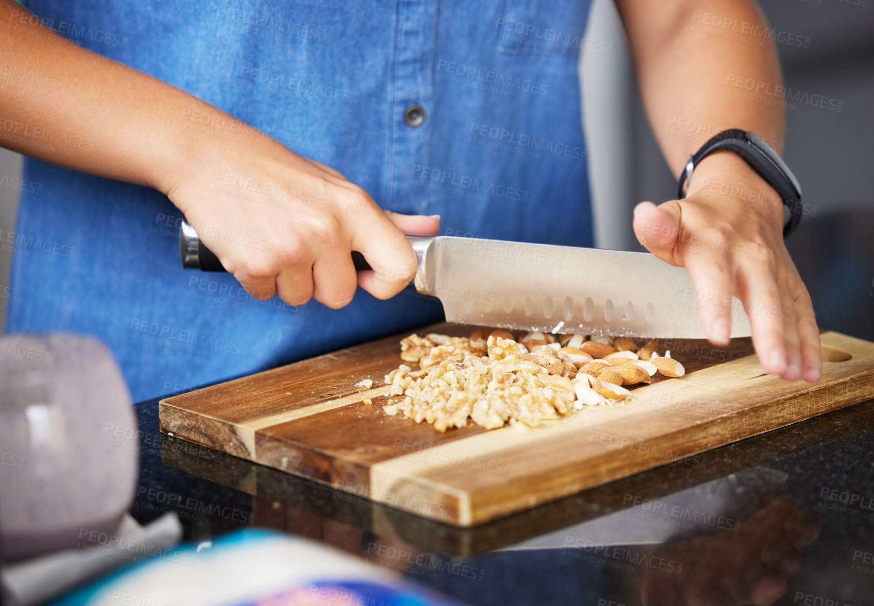 Buy stock photo Chopping board, hands and almond nuts for healthy food, snack and meal prep in kitchen with recipe. Person with knife and natural protein, nutrition or fiber for cooking vegan lunch or baking at home